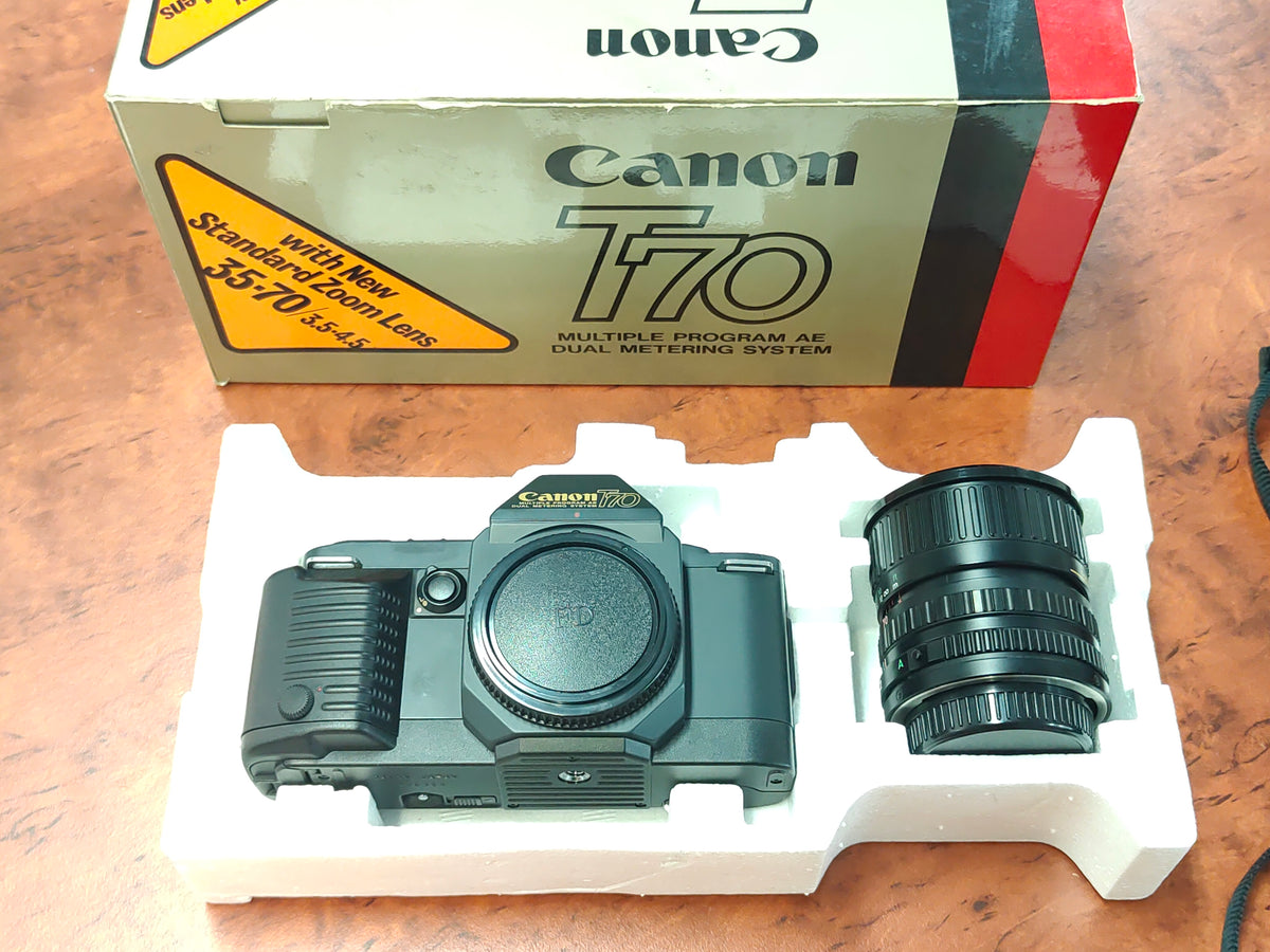 Canon T70 SLR camera + 35-70mm zoom lens in original box.